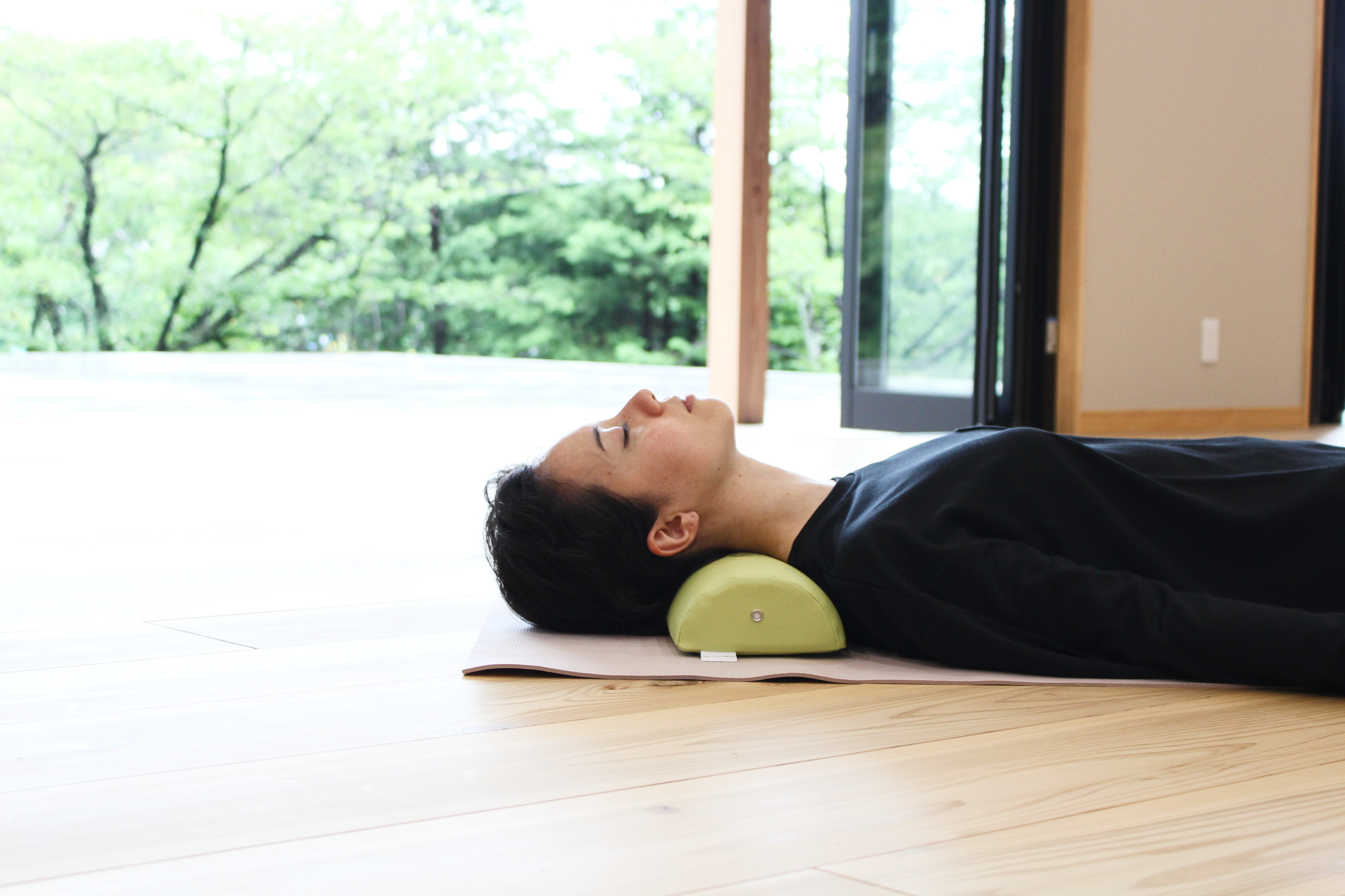A woman demonstrates using the NeckEz Pillow