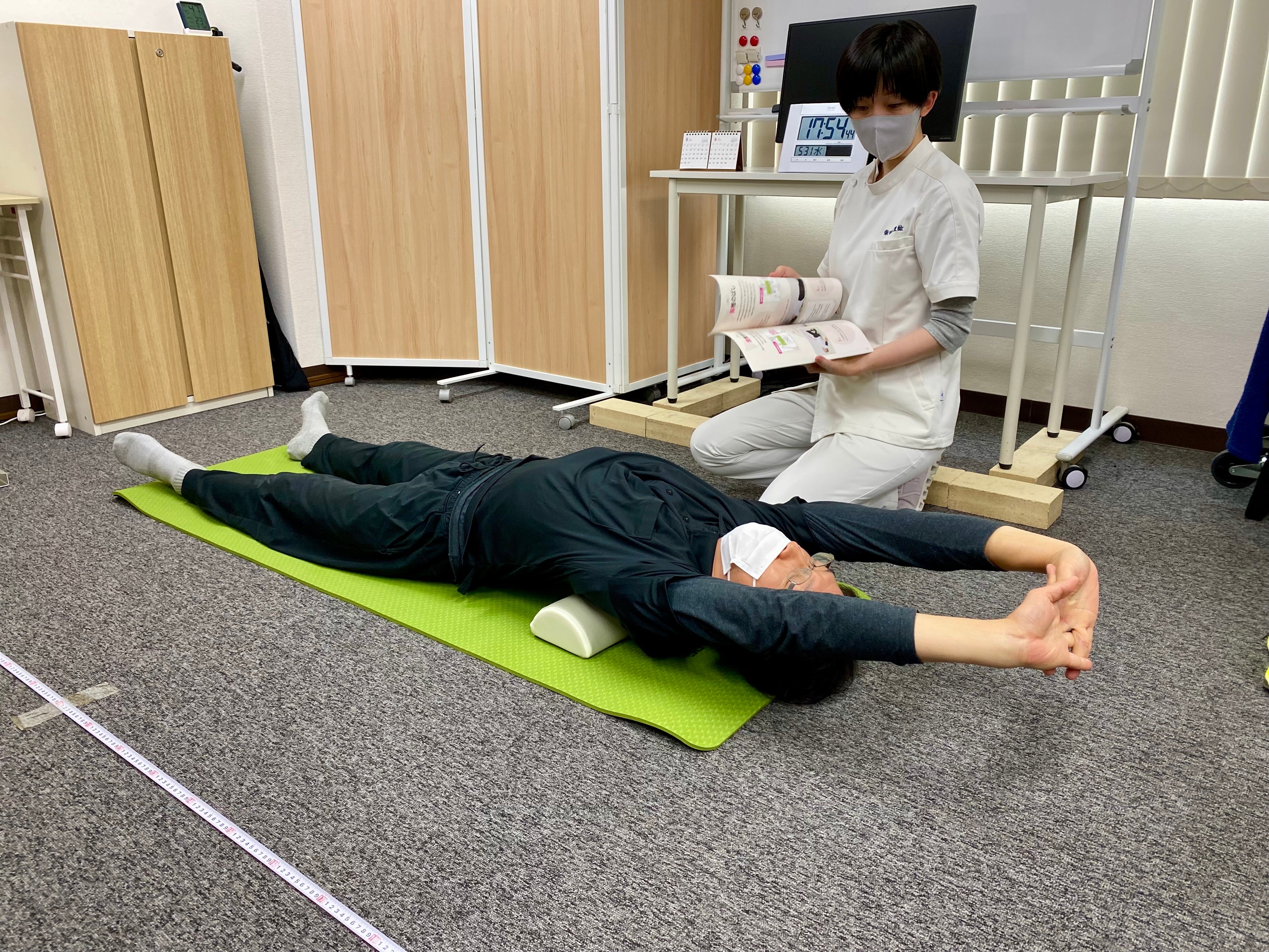 A researcher from FMT Seitai instructs a research subject on correct stretching exercises.